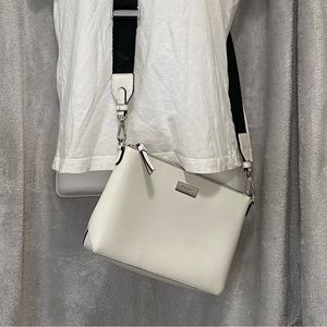 Crossbody DKNY white and removable guitar strap.